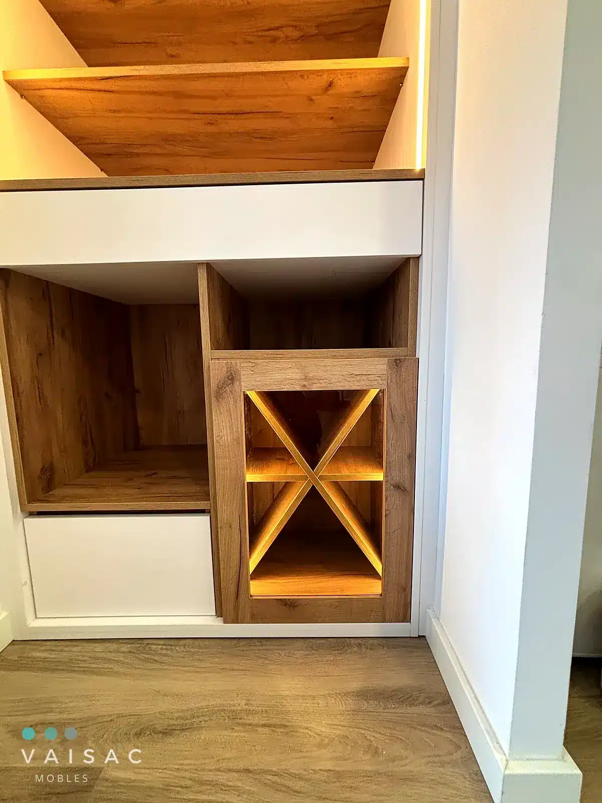 Detalle de botellero en aspa de roble con iluminación LED integrado en un mueble a medida bajo escalera