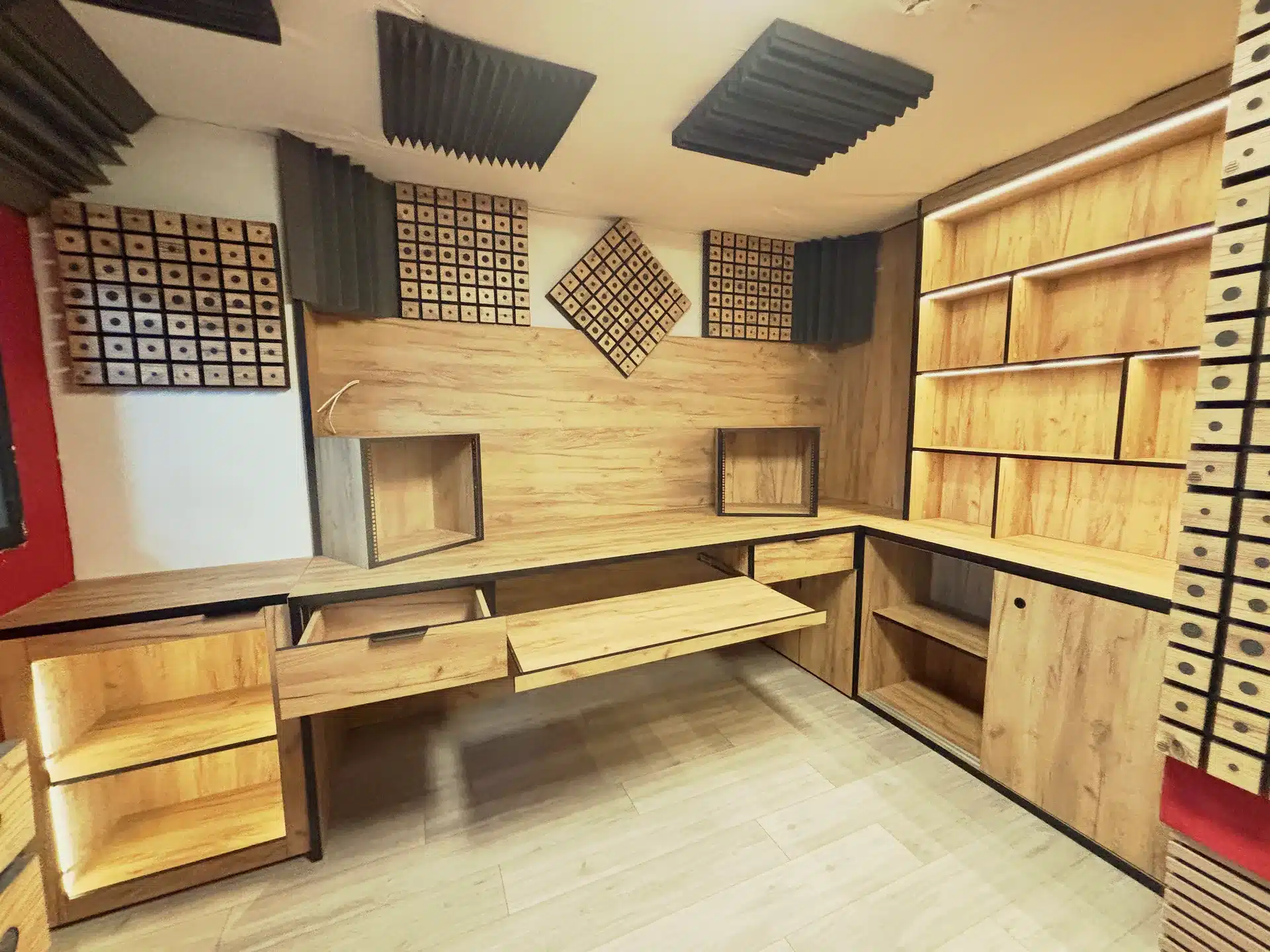 Vista panorámica completa de estudio de grabación profesional con muebles de madera a medida y tratamiento acústico